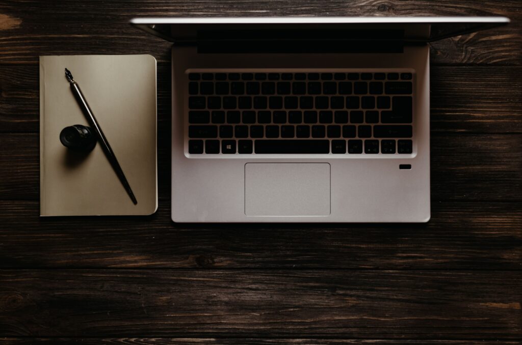 Laptop, pióro i notatnik